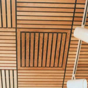 A close up of ASI Architectural wood grille ceiling panel