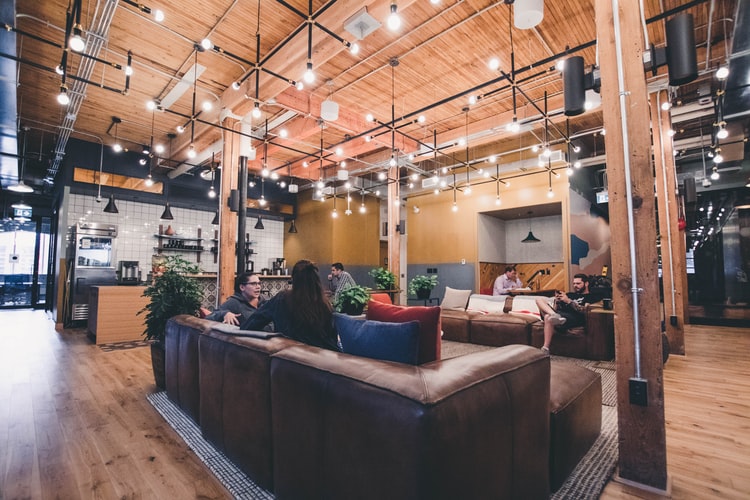 A modern open-concept lobby space features ASI architectural wooden acoustic paneling to reduce noise.