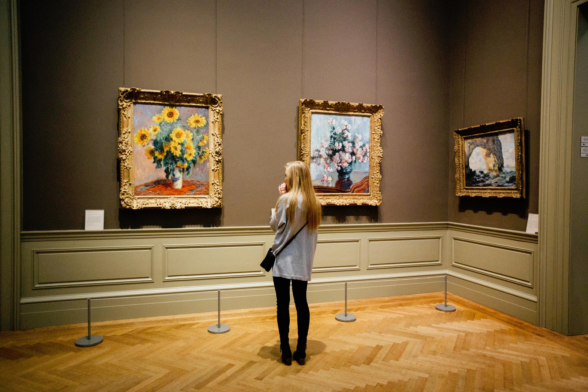 A woman gazes at still life portraits in an art museum equipped with ASI Architectural acoustic panels.