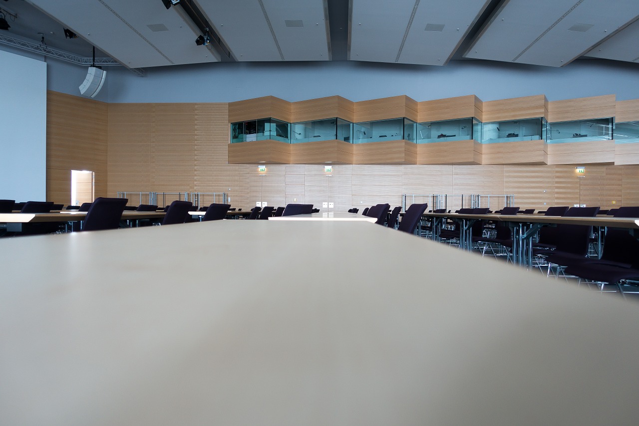 A large conference room in an academic building features wooden acoustic wall paneling by ASI Architectural